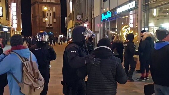 Polizisten sprechen in der Rostocker Innenstadt mit Teilnehmern einer untersagten Demonstration. © NonstopNews Foto: NonstopNews