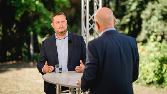 Der FDP-Politiker René Domke steht an einem Tisch während eines Interviews. © NDR Foto: Katharina Kleinke