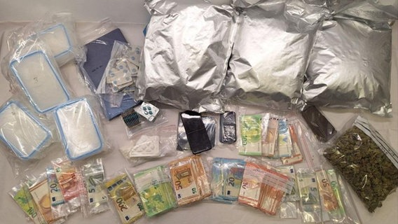 Ein Foto der Polizei zeigt beschlagnahmte Drogen umd Bargeld (undatierte Aufnahme). Die Polizei fand bei Durchsuchungen in Bad Doberan und Kröpelin unter anderem Marihuana, Kokain, Amphetamine und Bargeld. © Kriminalpolizeiinspektion Rostock/dpa Foto: Kriminalpolizeiinspektion Rostock/dpa