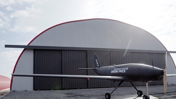Transportdrohne "Black Swan" der Firma Dronamics vor einem Hangar. © DRONAMICS 