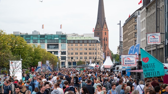 Zahlreiche Besucher sind auf dem Jungfernstieg zwischen verschiedenen Ständen unterwegs. Die Hansestadt Hamburg richtet in diesem Jahr die Feierlichkeiten zum Tag der Deutschen Einheit aus. © dpa Foto: Jonas Walzberg