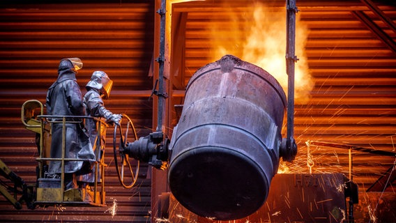 Arbeiter gießen flüssiges Eisen in vorbereitete Formen. © dpa-Bildfunk Foto: Jens Büttner