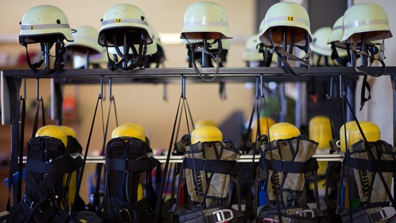 Feuerwehrhelme und Atemschutzgeräte hängen in einer Gerätehalle der Landesschule für Brand- und Katastrophenschutz in Malchow . © dpa-Bildfunk Foto: Jens Büttner
