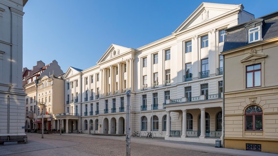 Die Fassade des Finanzministeriums Mecklenburg-Vorpommerns in Schwerin, die obere Hälfte wird von der Sonne angestrahlt. © picture alliance / imageBROKER Foto: Olaf Döring