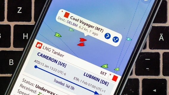 Auf dem Display eines Smartphone ist auf der App MarineTraffic die aktuelle Position des LNG-Tankschiffs "Cool Voyager" im Skagerrak nördlich von Dänemark zu sehen © Jens Büttner/MarineTraffic/dpa 