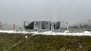 Ein ausgebrannter Transporter steht in Mitten von weißem Löschschaum. © NDR Foto: Felix Gadewolz