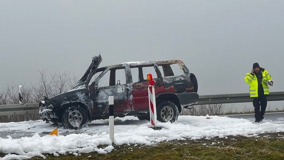 Ein ausgebrannter Geländewagen steht in Mitten von weißem Löschschaum. © NDR Foto: Felix Gadewolz