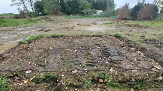 Das geräumte Gelände einer Kleingartenanlage, das Fundament einer Laube.  