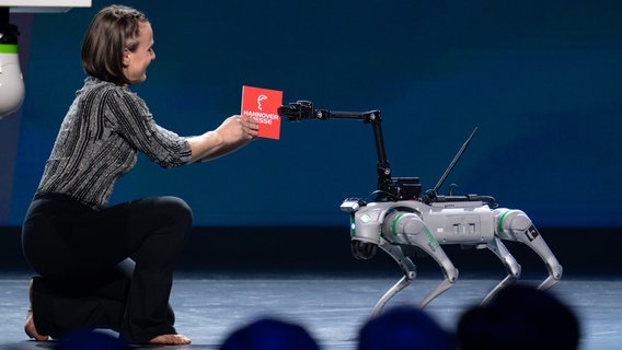 Während der Aufführung von Kanada auf der Eröffnungsfeier überreichte eine Frau einem Roboter eine Karte mit der Aufschrift "Hannover Messe". © Rainer Jensen Foto: Rainer Jensen