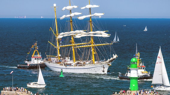 Pelatihan kapal layar Angkatan Laut Jerman "George Fock"Setelah pelayaran di Laut Baltik sebagai bagian dari Hanse Sail, dia berlayar menyusuri Channel Sea di Warnemünde dengan dukungan kapal tunda pelabuhan dan disambut di kepala tahi lalat oleh banyak penonton.  © dpa Foto: Jens Buttner