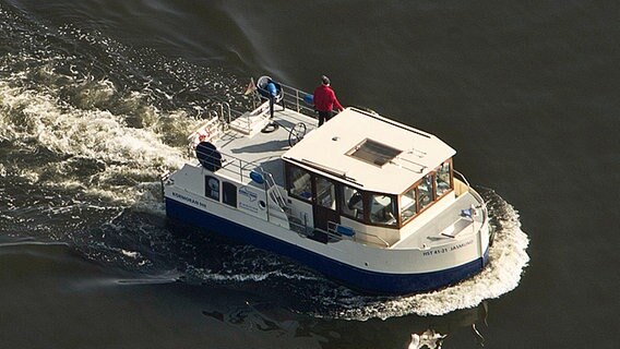 Zwei Männer fahren mit dem Hausboot "Jasmund" von der Greifswalder Oie nach Fresst. © dpa Foto: Stefan Sauer