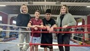 Julia Pietschmann (l.) und Chiara Schreiter stehen zusammen mit den beiden Teilnehmern der Rostocker Hobby Lobby Michael Bliss (2. v. l.) und Berat Durmaz in einem Boxring. © NDR, Carolin Beyer Foto: Carolin Beyer