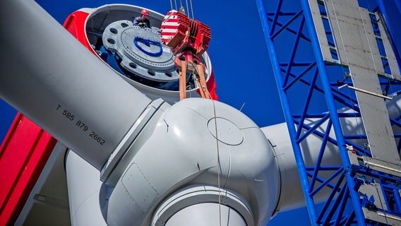Windpark in Hoort: Mit einem Spezialkran wird der vormontierte Propeller an das Maschinenhaus einer Windkraftanlage gehoben. © dpa-Bildfunk Foto: Jens Büttner