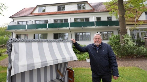 Graal-Müritz: Detlef Nippkow, Inhaber der Pension "Haus am Meer", steht vor seinem Hotel neben einem Strandkorb. © dpa-Bildfunk Foto: Bernd Wüstneck
