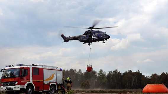 Ein Löschhubschrauber ist in einem Waldstück nahe Jüterbog im Einsatz. © dpa Foto: Sven Kaeuler