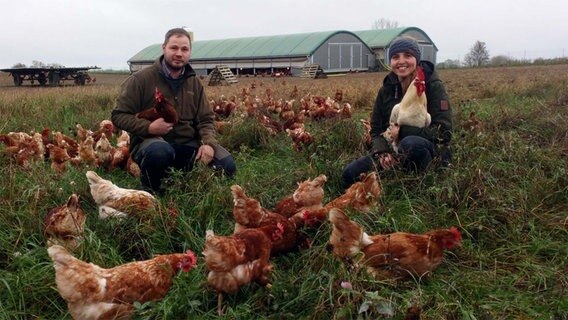 Hühnerhalter mit Hennen vor einem Hühnermobil © NDR Foto: Jörg Wartmann