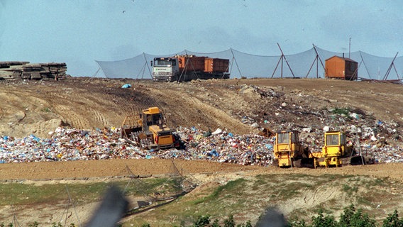 Lastwagen kippen auf der Mülldeponie ihre Ladung ab. (Aufnahme von 1991) © picture-alliance/ ZB Foto: Jens Büttner