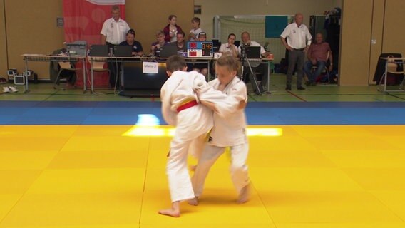 Das Bild zeigt zwei junge Judoka auf einer gelben Matte beim Wettkampf. © NDR Foto: Screenshot