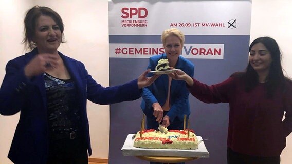 Gayane Kirakosjan schneidet mit Ministerpräsidentin Manuela Schwesig und der damaligen Integrationsbeauftragten des Landes und jetzigen Staatsministerin für Integration, Reem Alabali-Radovan.  