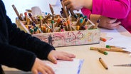 Kinderhände greifen in eine Holzbox mit Stiften. (Kita "Naturtalent" Ludwigslust, MV) © Picture Alliance Foto: Jens Büttner/ZB/dpa