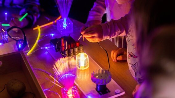Kita-Kinder in Schwerin bringen LED-Lämpchen zum Leuchten, die sie selbst gebastelt hatten. © dpa Foto: Jens Büttner