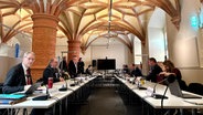 Der parlamentarische Untersuchungsausschuss im Landtag: zwei langgezogene Tische mit Sitzreihen stehen sich direkt gegenüber. Der Raum ist ein altes Gewölbe im Schweriner Schloss. © NDR Foto: Mattes Scholze