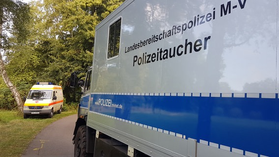 Ein Einsatzwagen der Landesbereitschaftspolizei und ein Rettungswagen stehen an einem Weg. © NDR Foto: Ullrich-Lars Houschka