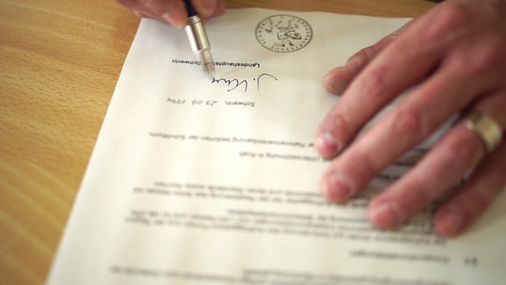 Ein Dokument wird unterschrieben. © NDR Foto: NDR