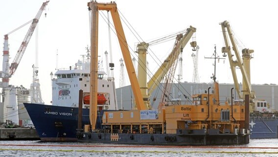 Der Spezialkran "Baltic Lift" im Rostocker Seehafen neben dem Schwergutschiff "Jumbo Vision" (l.), von dem aus bei einem Unfall zwei mobile Hafenkräne bei ihrer Verladung in das Hafenbecken gestürzt sind. © Bernd Wüstneck/dpa-Zentralbild Foto: Bernd Wüstneck/dpa-Zentralbild