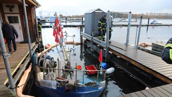Ein Fischkutter ragt nur noch zu einem kleinen Teil aus dem Wasser im Rostocker Hafenbecken. Das Boot ist an seinem Liegeplatz gesunken. © Stefan Tretropp Foto: Stefan Tretropp