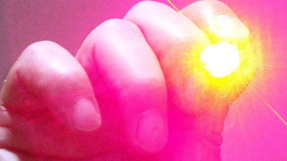 ein Laserpointer ist auf die Kamera gerichtet © picture-alliance Foto: Patrick Lux