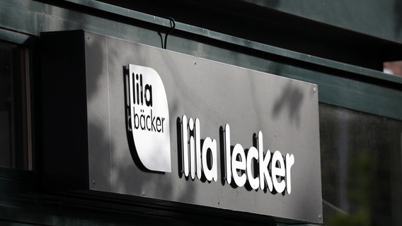 Das Logo des Unternehmens Lila Bäcker mit dem Schriftzug "lila lecker" an einer Filiale. © dpa Foto: Bernd Wüstneck