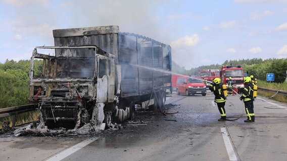 Feuerwehrleute löschen einen mit Holzplatten beladenen Lkw auf der A19. © Stefan Tretropp Foto: Stefan Tretropp