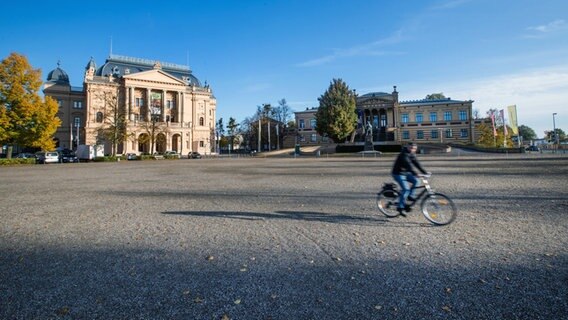 Schwerin: Ein Radfahrer ist zwischen den Staatlichen Museum (r) und dem Mecklenburgischen Staatstheater (l) unterwegs. © dpa-Bildfunk Foto: Jens Büttner