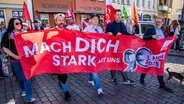 Menschen halten einen Banner mit den Worten "Mach dich stark für uns" hoch © Jens Büttner / dpa Foto: Jens Büttner