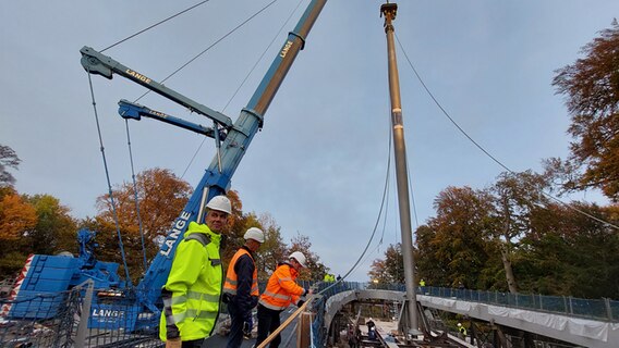 Der mehr als 40 Meter lange Mast, an dem später der ellipsenförmige Rundgang hängen soll, wurd am Donnerstagnachmittag aufgestellt. © Michaele Rüting 