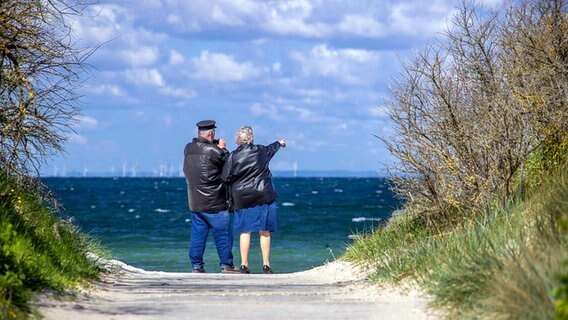 Timmendorf (Poel): Ein Rentnerpaar steht am ansonsten menschenleeren Strand und schaut aufs Meer. © dpa-Bildfunk Foto: Jens Büttner