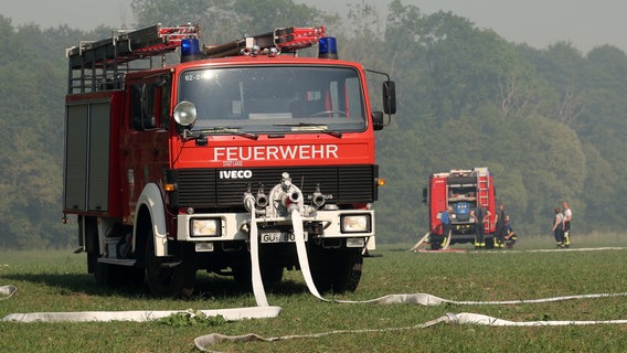 Ein Feuerwehrfahrzeug an dem brennenden Wald- und Torfmoorgebiet. Wegen des unwegsamen Geländes mussten Schläuche hunderte Meter weit verlegt werden. © dpa Foto: Bernd Wüstneck