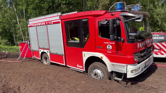 Ein Feuerwehrfahrzeug, das sich im Erdreich nahe des brennenden Wald- und Torfmoorgebiet bei Göldenitz festgefahren hat. Wegen des unwegsamen Geländes mussten Schläuche hunderte Meter weit verlegt werden. © NDR Foto: NDR