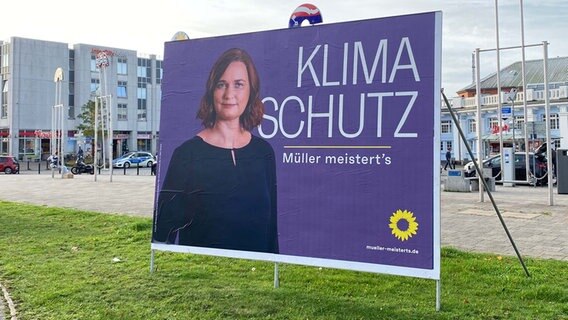 Wahlplakat mit lilafarbenem Hintergrund von Claudia Müller, OB-Kandidatin der Grünen in Rostock vor dem Rostocker Hauptbahnhof. © NDR.de Foto: Judith Greitsch/NDR.de
