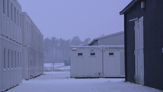 Leere Wohncontainer stehen auf einem verlassenen, verschneiten Gelände bei Murchin. © NDR Foto: NDR