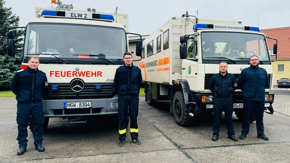 Vier Einsatzkräfte des Katastrophenschutzes stehen vor zwei Einsatzfahrzeugen. Vier Einsatzkräfte des Katastrophenschutzes stehen vor zwei Einsatzfahrzeugen. © Landkreis Vorpommern-Greifswald