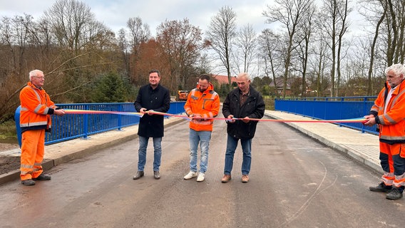 Landrat Sebastian Constien durchschneidet gemeinsam mit Bauleiter Björn Niemann und dem stellvertretenden Bürgermeister Uwe Bohnsack das symbolische Schleifenband. Landrat Sebastian Constien durchschneidet gemeinsam mit Bauleiter Björn Niemann und dem stellvertretenden Bürgermeister Uwe Bohnsack das symbolische Schleifenband. © Landkreis Rostock Foto: Landkreis Rostock