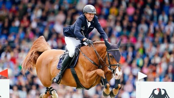 Der deutsche Reiter Andre Thieme auf dem Pferd Chakaria springt über ein Hindernis. © Uwe Anspach/dpa 