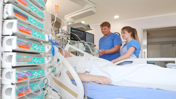 Zwei Mitarbeitende der Intensivstation stehen am Krankenbett. © Universitätsmedizin Rostock Foto: Danny Gohlke