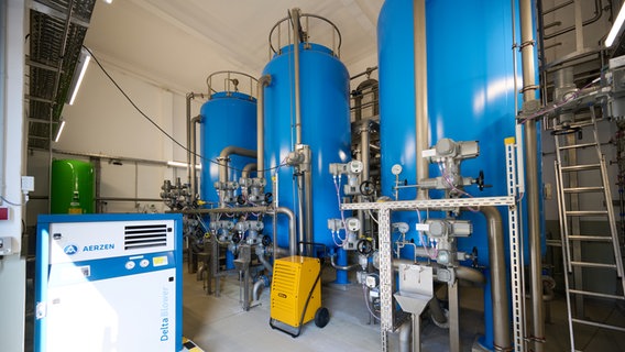 Im Inneren des Wasserwerkes in Fienstorf stehen drei blaue Tanks mit Leitungen und Armaturen davor. © Nordwasser 