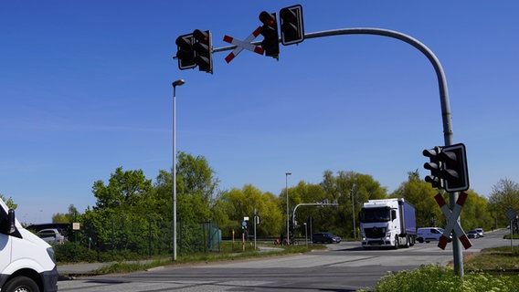Eine Kreuzung durch die Schienen verlaufen. Ein Lastwagen fährt um die Kurve. © NDR Foto: Christoph Woest