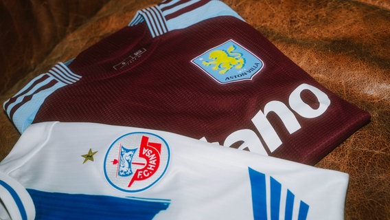 Zwei gefaltete Fußbaltrikots. Eines von Hansa Rostock und eines von Aston Villa © F. C. Hansa Rostock Foto: Oliver Krahn