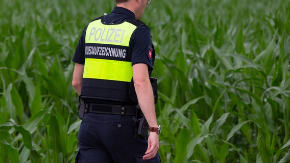 Ein Polizist geht am Rande eines Maisfeldes auf Streife. (Themenbild) © picture alliance Foto: picture alliance/Fotostand/Gelhot