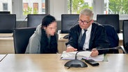 Die verurteilte Mutter (unkenntlich gemacht) sitzt mit ihrem Anwalt im großen Saal des Rostocker Landgerichts. © NDR Foto: Juliane Mau